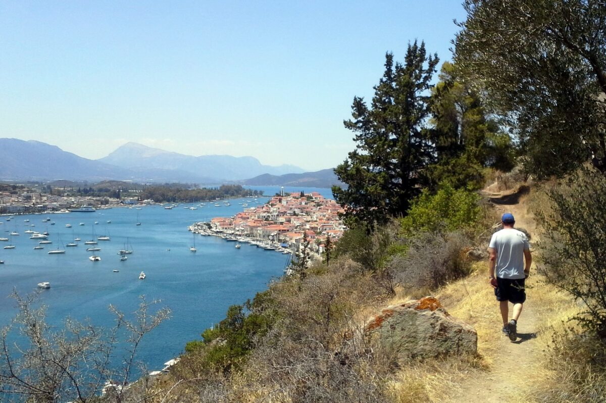 A hiker walking towards Poros town