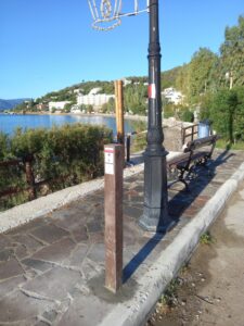 A recycled plastic pole with directions at the Poros Trails network with a white and red trail blaze behind it